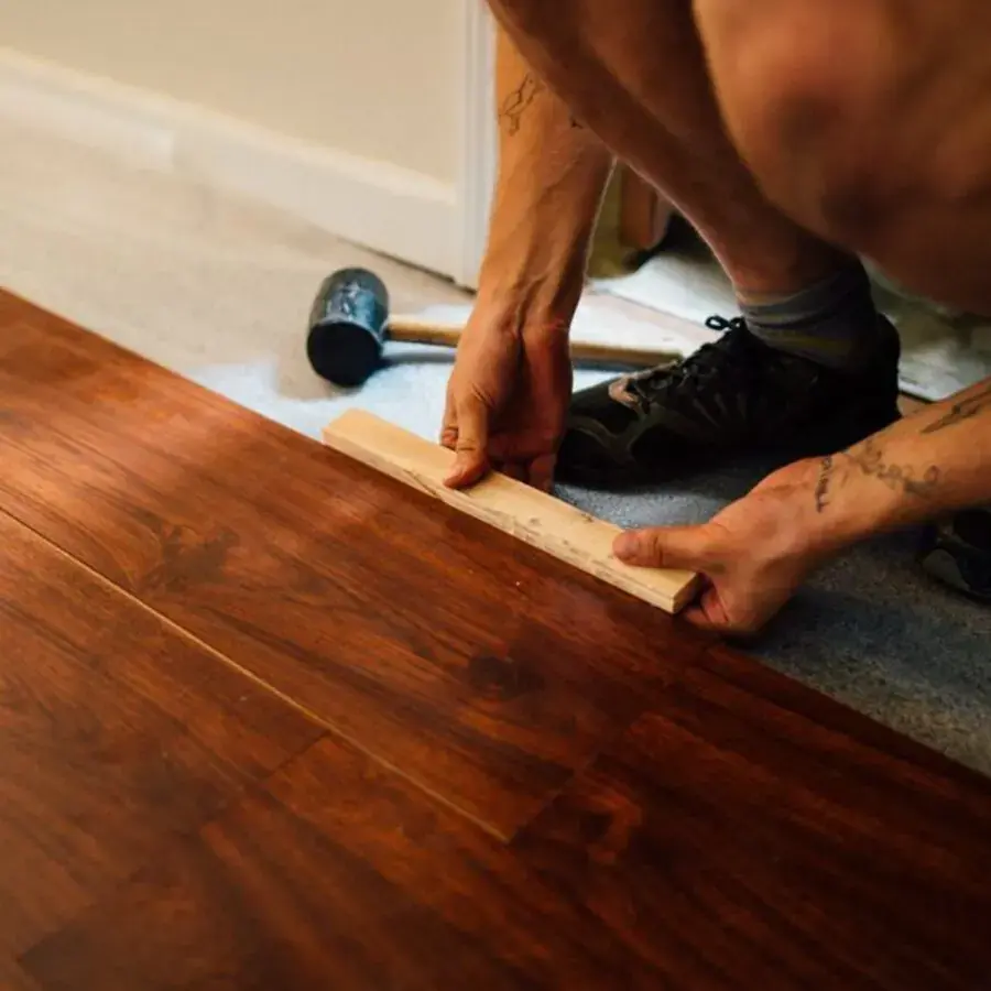 Flooring installer fitting timber floorboards indoors — Systemly builds automated follow-up and booking systems for flooring companies