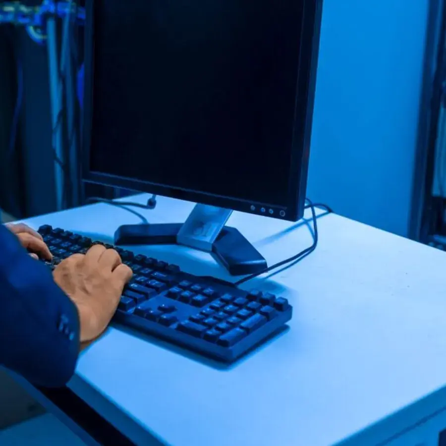 IT technician typing on a keyboard in a server room lit with blue light in Perth — Systemly builds automated onboarding and ticketing systems for IT support businesses