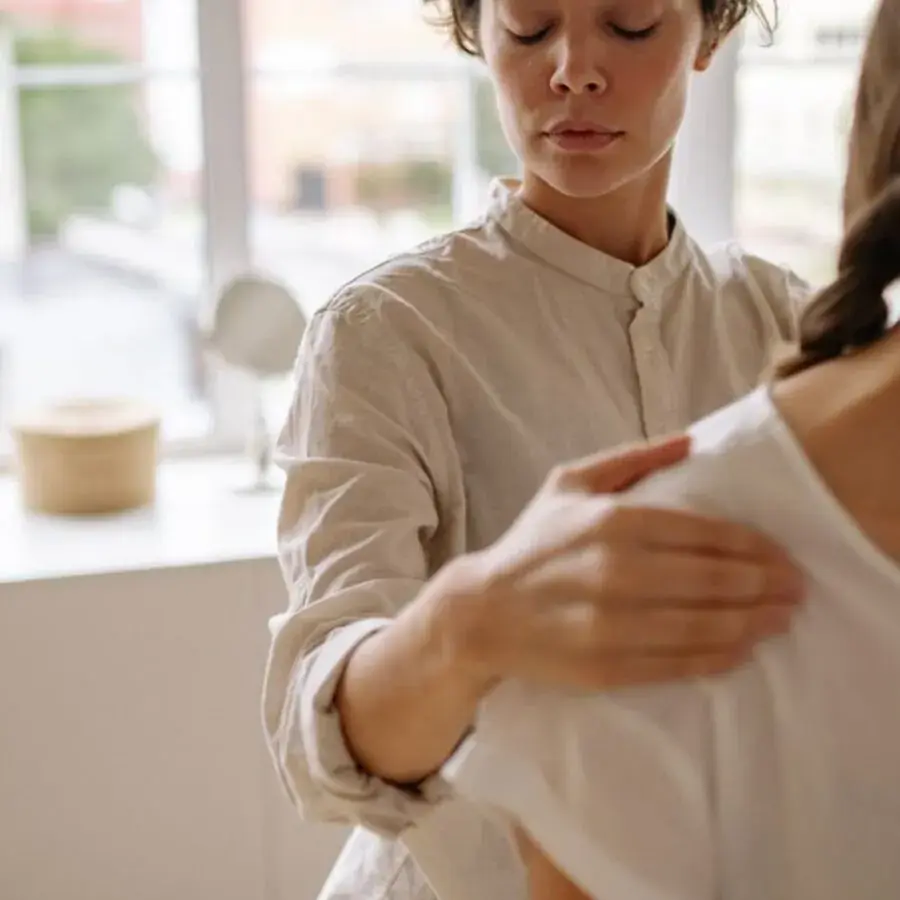 Physiotherapist gently treating a client's shoulder in a bright Perth clinic — Systemly builds automated booking and reminder systems for physiotherapy clinics